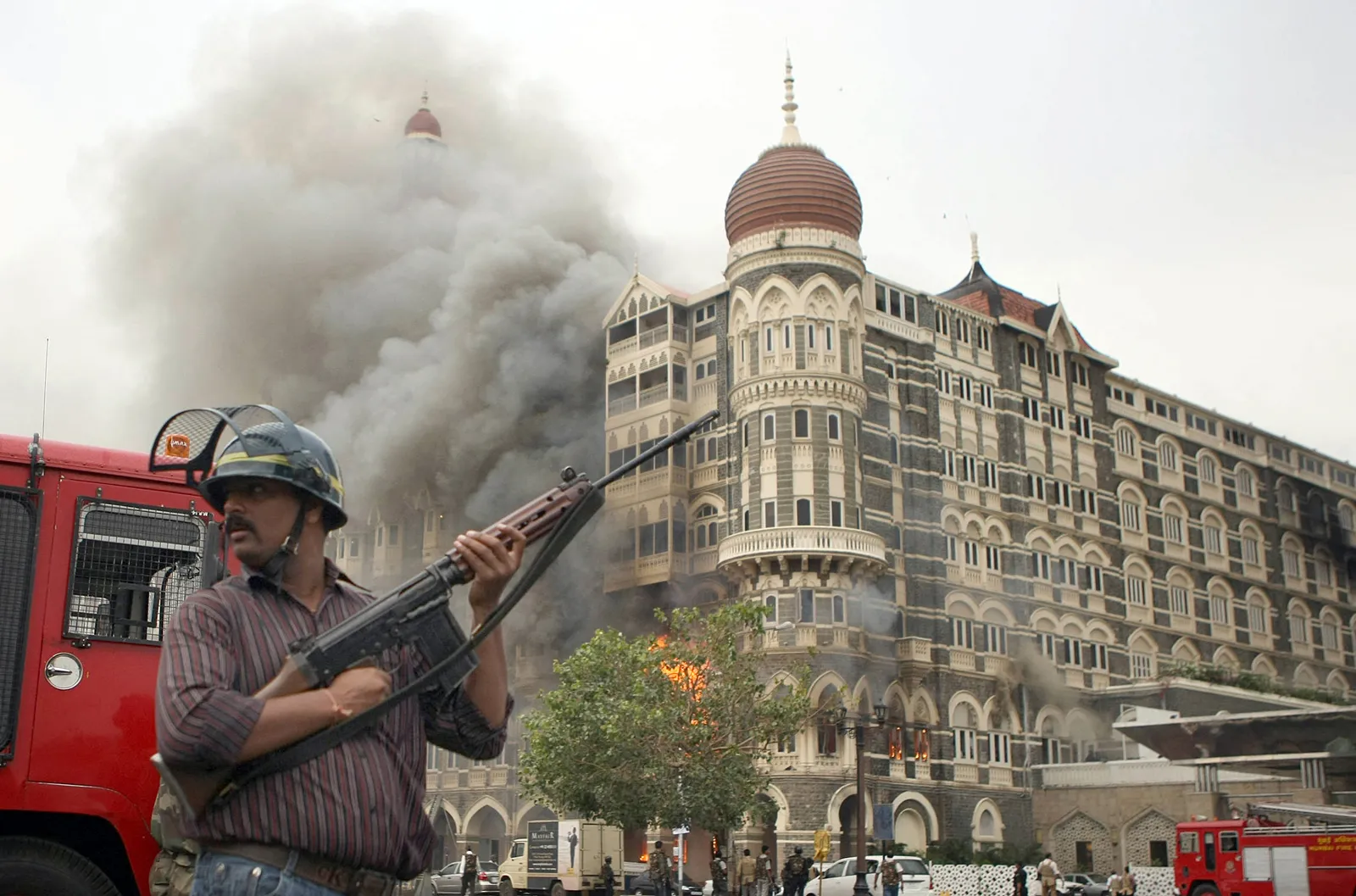 Security Official Stands Alert As Smoke And Flames Billow From A Section Of The Taj Mahal Hotel In Mumbai On November 29 2008
